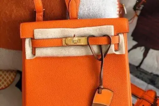 Hermes Kelly Ado Backpack Orange in premium leather with gold hardware – a bold luxury backpack inspired by the iconic Hermes Kelly Bag.